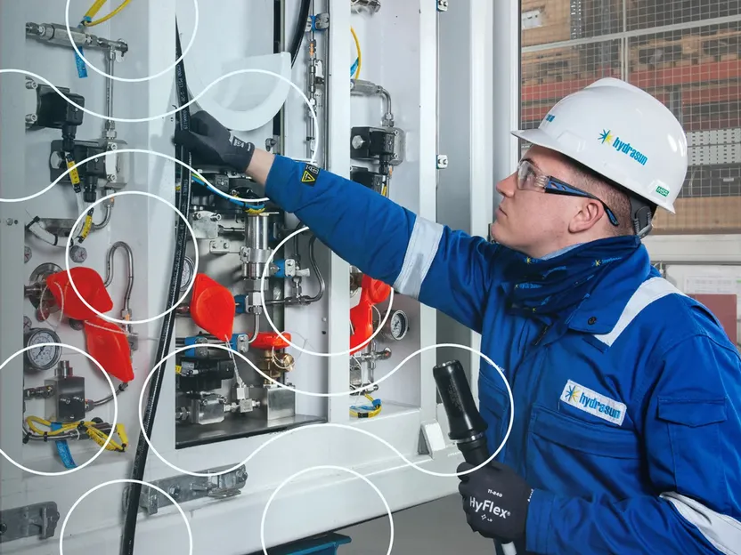 A Hydrasun engineer in a blue boiler suit and white hard helmet
